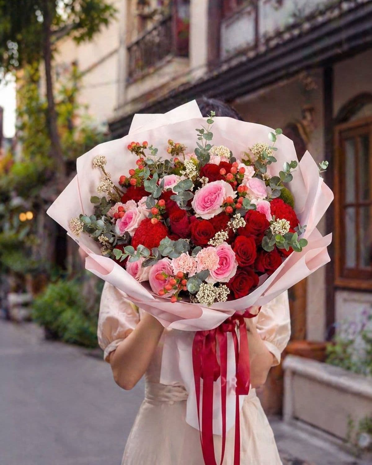Express your deepest feelings with this elegant arrangement of premium crimson and blush pink roses. Accented with unique red celosia and ruffled carnations, this textured bouquet offers a sophisticated look for anniversaries or romantic surprises. Fresh eucalyptus and delicate white fillers add a natural touch, all beautifully presented in a soft pink wrap with a burgundy ribbon. It is a perfect choice for premium gifting in Chiang Mai.