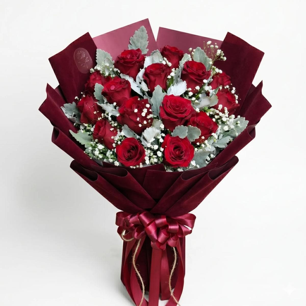 A bold and romantic rose bouquet arranged in a rounded hand-tied style. Rich, full, and beautifully textured with delicate baby’s breath and signature greenery. Perfect for anniversaries, birthdays, celebrations, or a grand romantic gesture—classic, elegant, and unforgettable.